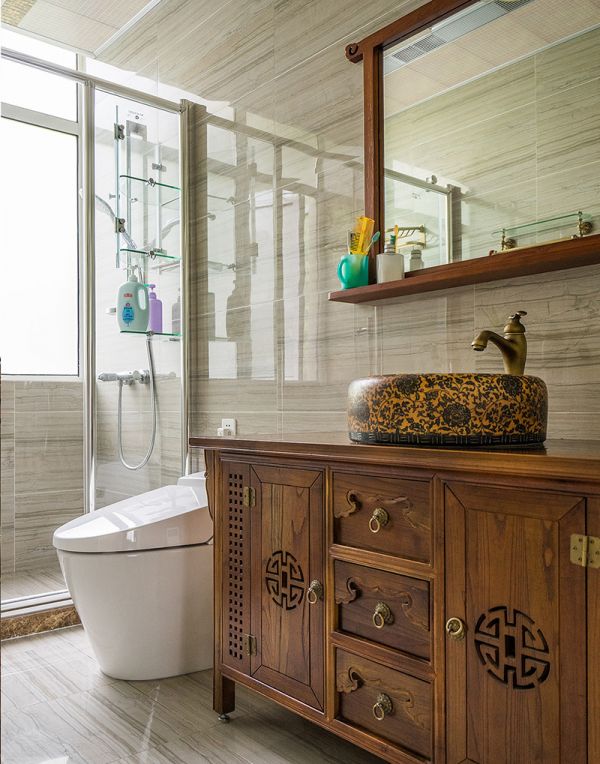 卫生间干湿两块部分，洗手盆是相对来说湿度比较小的区域，所以也采用了和整体风格一致的木质矮柜。