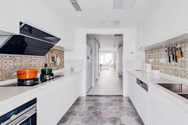 厨房大面积的白色、灰色延续了整体风格的清冷基调，地面六角形仿水泥地砖和屋外白色木地板过度自然。