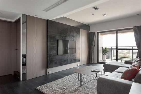深色地坪与电视墙对比木皮染灰的立面设计，以材质带出质感气度、以色阶创造空间层次。
